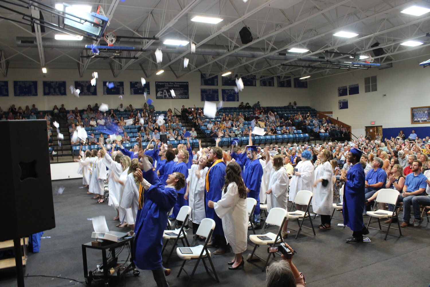 Class of 2020 Hartville graduates throw their caps in the air to celebrate.